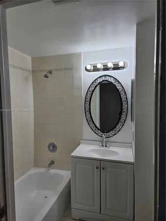 a bathroom with a bathtub a mirror a sink and vanity