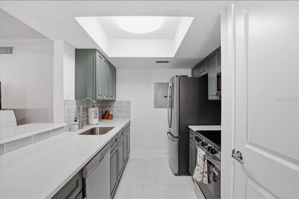 8911 Blind Pass Road, Unit 118 St. Pete Beach, FL 33706 - Photo 16 of 34 a kitchen with refrigerator and cabinets