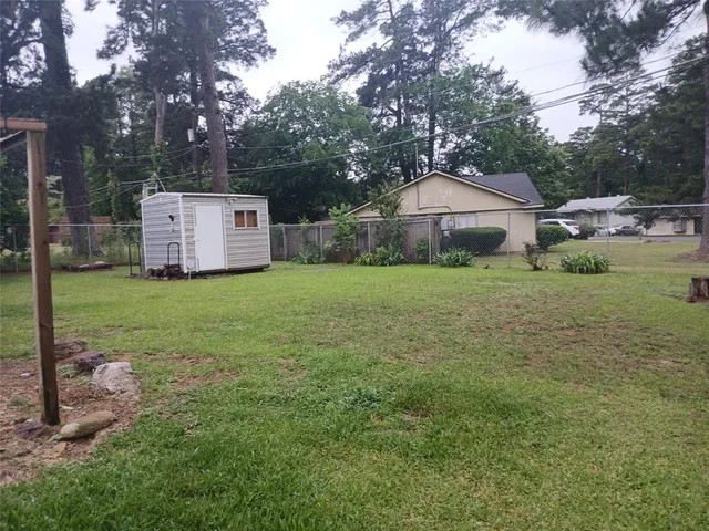 a white house with a big yard and large trees