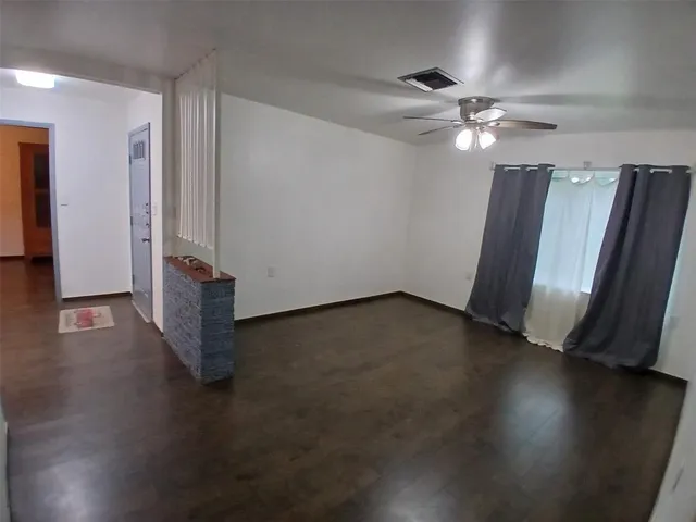an empty room with wooden floor and window