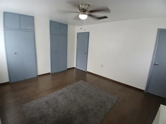an empty room with a ceiling fan and a window