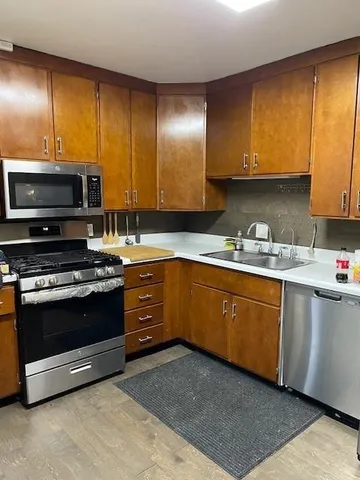 a kitchen with stainless steel appliances granite countertop a stove a sink and a microwave