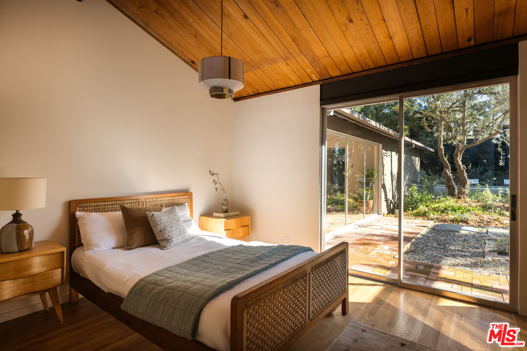 390 North San Rafael Avenue Pasadena, CA 91105 - Photo 19 of 39 a bedroom with a bed and wooden floor