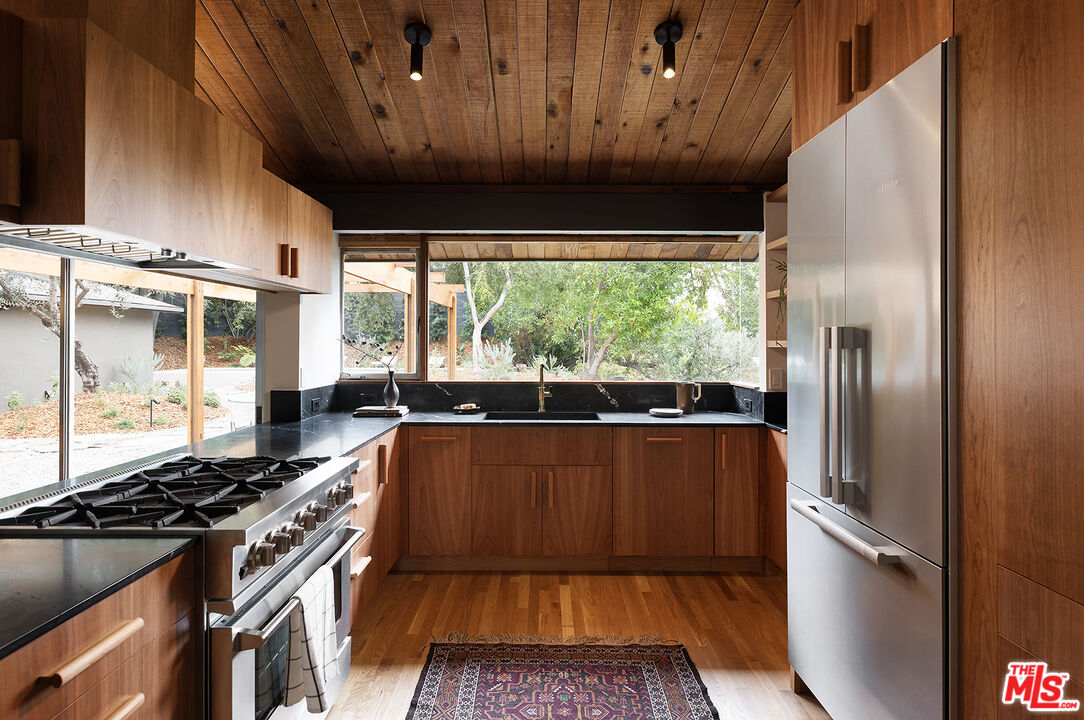 390 North San Rafael Avenue Pasadena, CA 91105 - Photo 8 of 39 a kitchen with stainless steel appliances granite countertop a stove a refrigerator and a sink