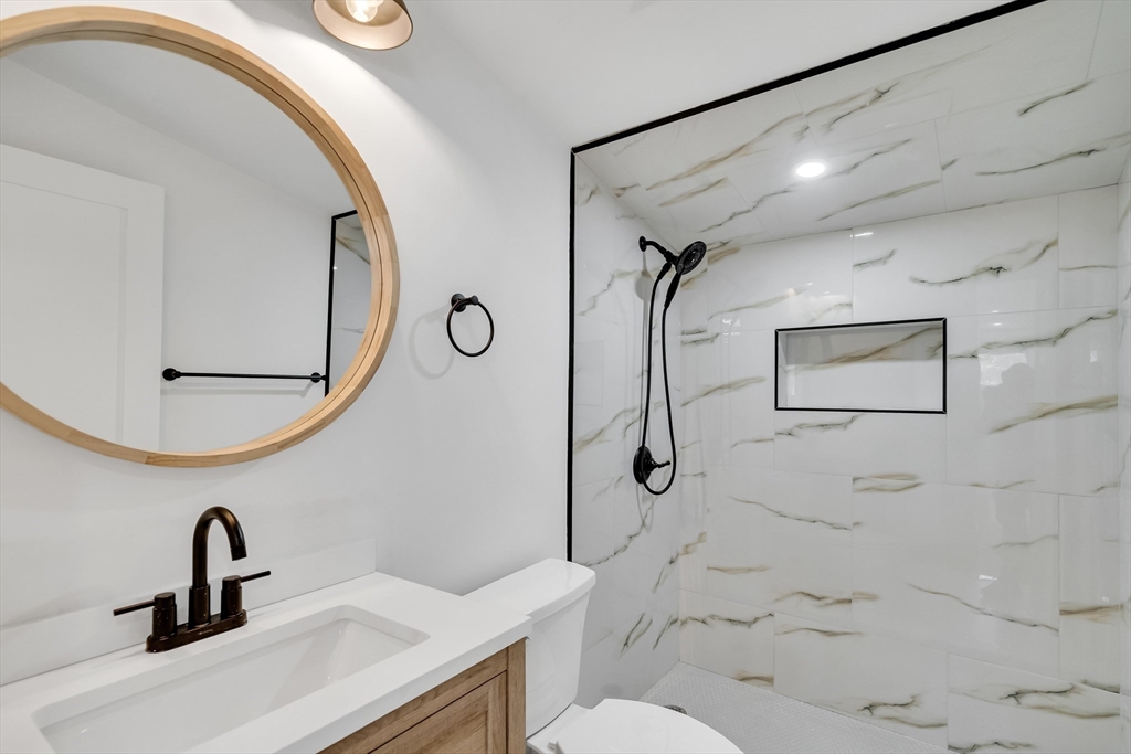 39 Abbott Road Waltham, MA 02452 - Photo 11 of 18 a bathroom with a toilet sink and mirror