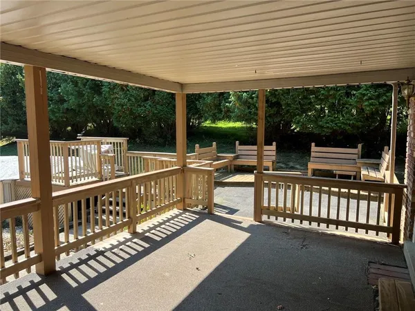 a view of a porch with wooden floor and outdoor seating
