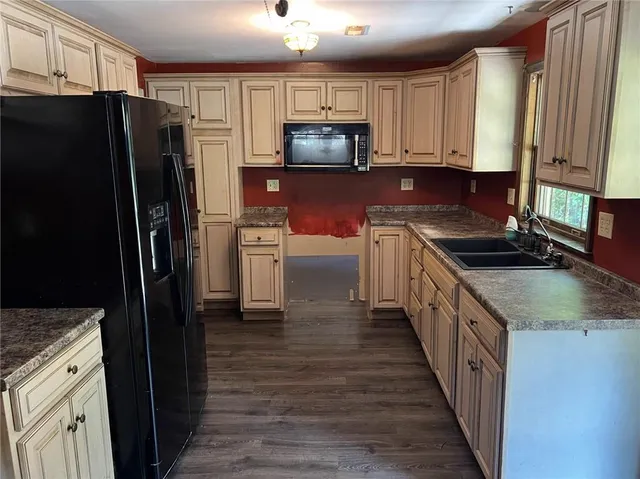 a kitchen with granite countertop a refrigerator stove and sink