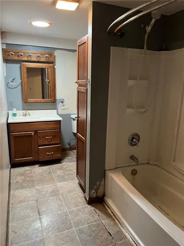 a bathroom with a tub sink and mirror