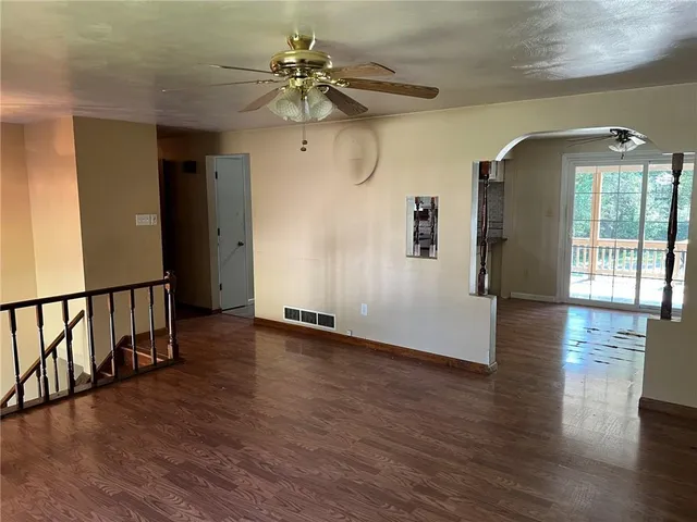 a view of a livingroom with wooden floor and a ceiling fan