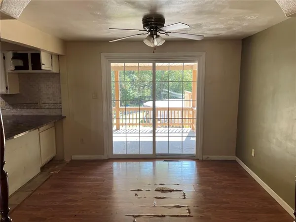 a view of an empty room with a window and wooden floor