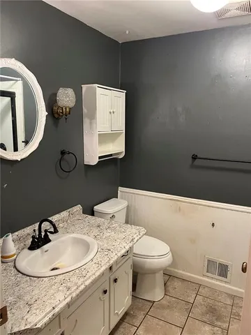 a bathroom with a toilet a sink and mirror
