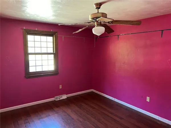 a view of a room with a wooden floor and fan