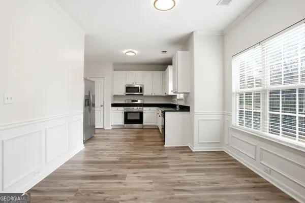 a kitchen with wooden floors and appliances