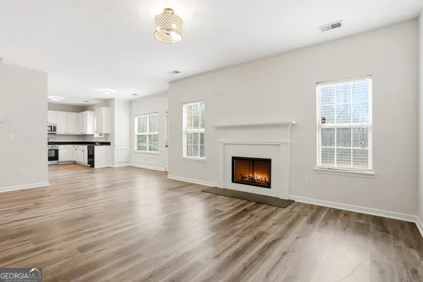 a view of a livingroom with wooden floor a fireplace and window