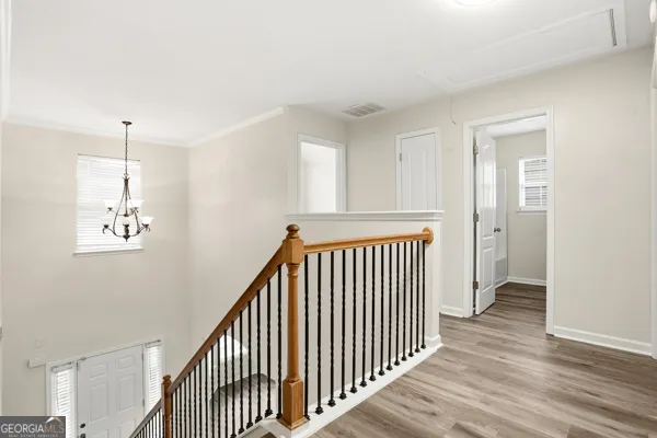 a view of a hallway with wooden floor and staircase