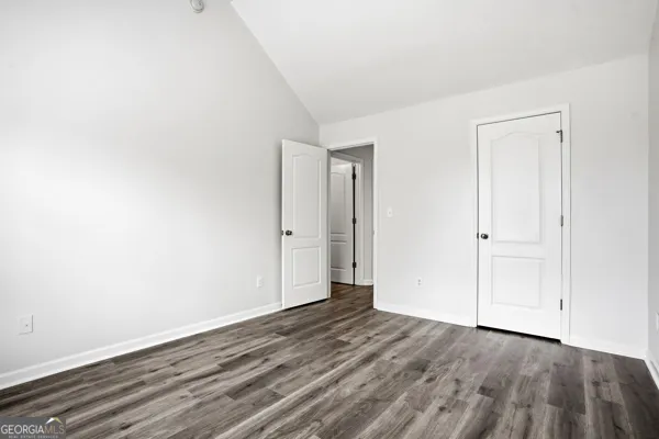 a view of an empty room with wooden floor