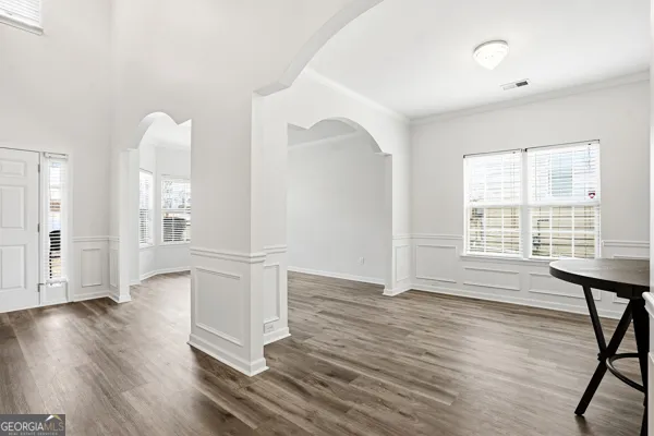 an empty room with wooden floor and windows
