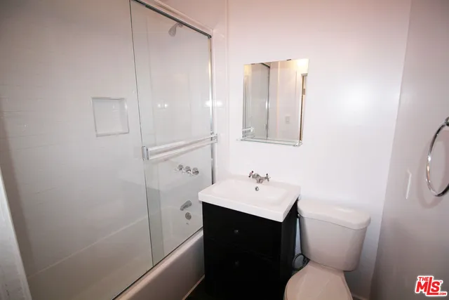 a bathroom with a sink toilet vanity and tub