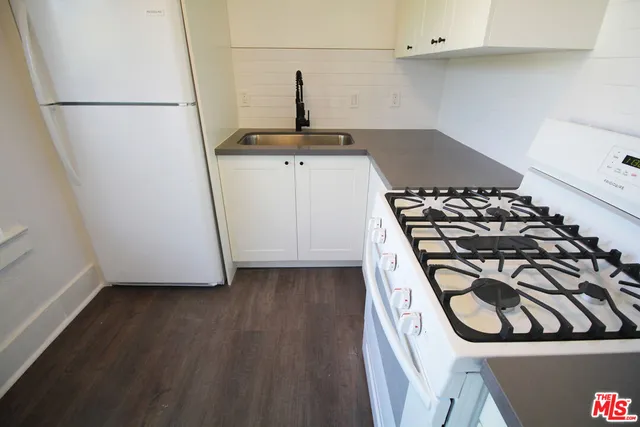 a kitchen with wooden cabinets and a stove top oven