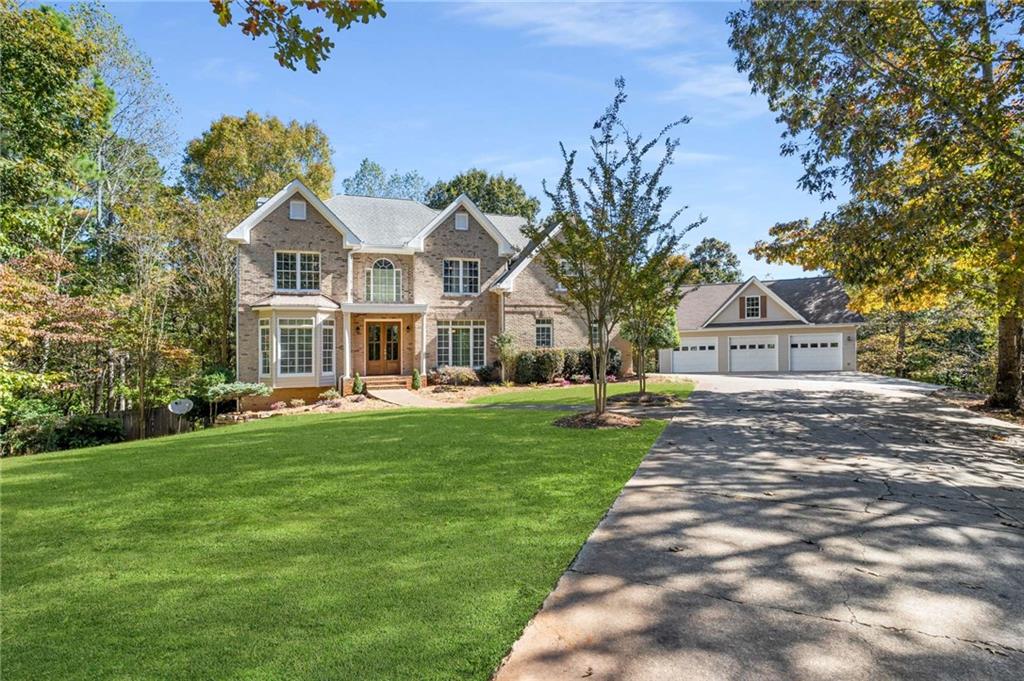 a front view of a house with a garden and trees