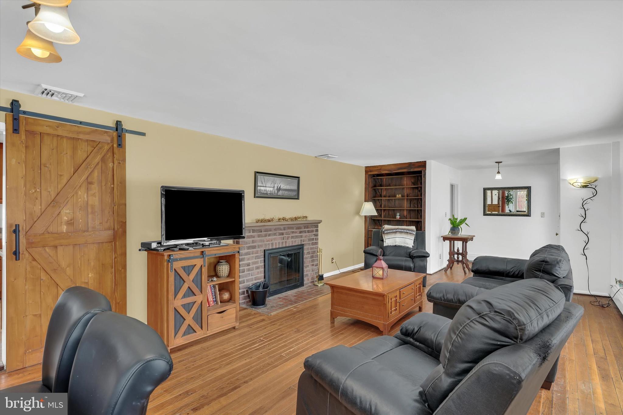 6246 Point Pleasant Pike Doylestown, PA 18902 - Photo 7 of 40 a living room with furniture a flat screen tv and a fireplace