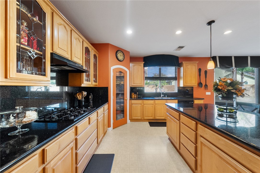 6920 Channel Court Eastvale, CA 91752 - Photo 13 of 57 a kitchen with stainless steel appliances granite countertop a stove a sink and a microwave