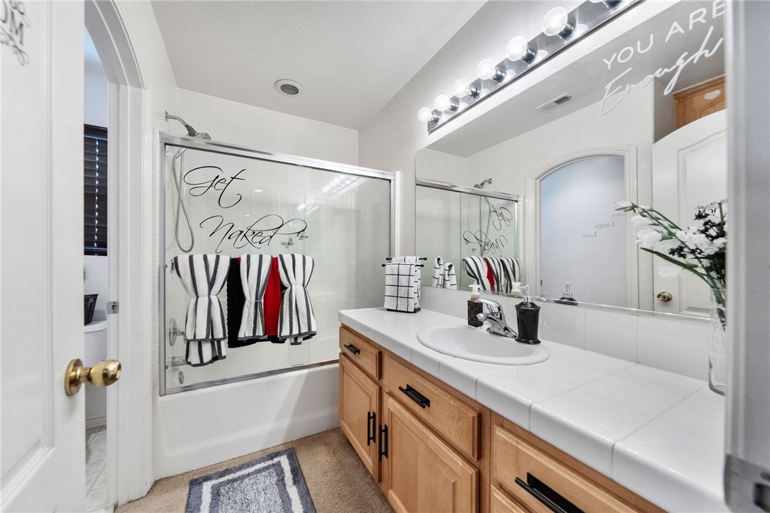 6920 Channel Court Eastvale, CA 91752 - Photo 31 of 57 a bathroom with a sink a mirror and a shower