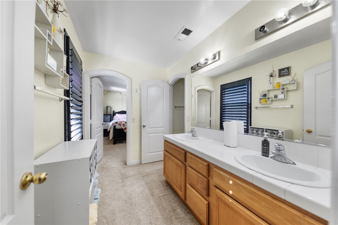 6920 Channel Court Eastvale, CA 91752 - Photo 33 of 57 a en suite spacious bathroom with double vanity and mirrors