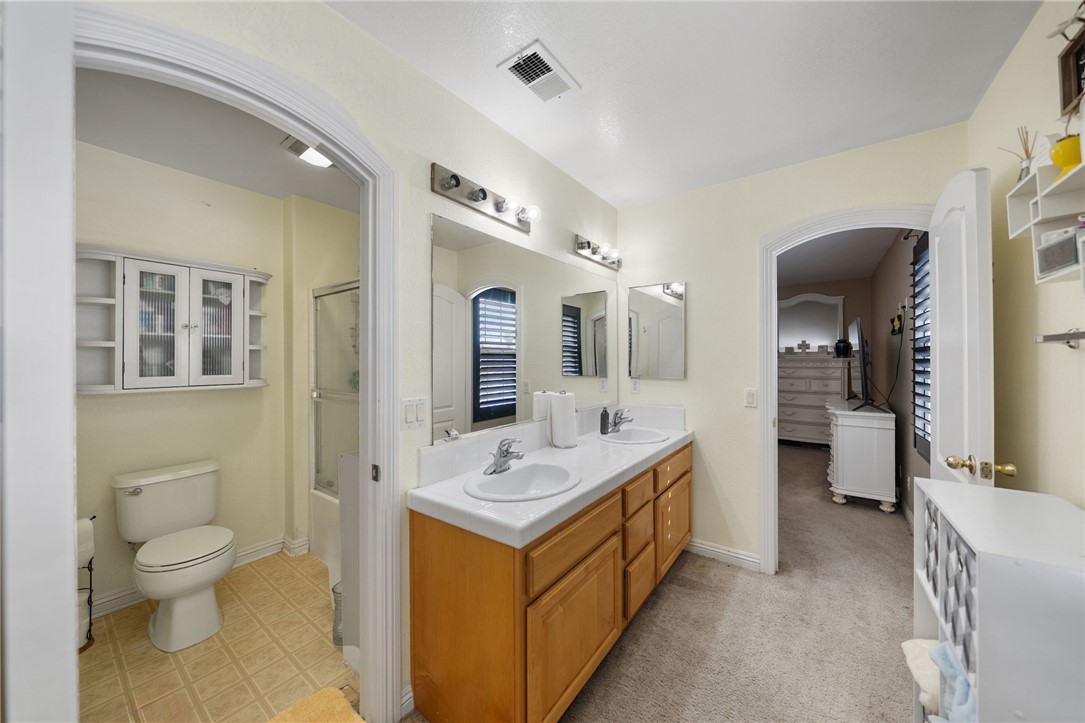6920 Channel Court Eastvale, CA 91752 - Photo 37 of 57 a bathroom with a sink a toilet and mirror