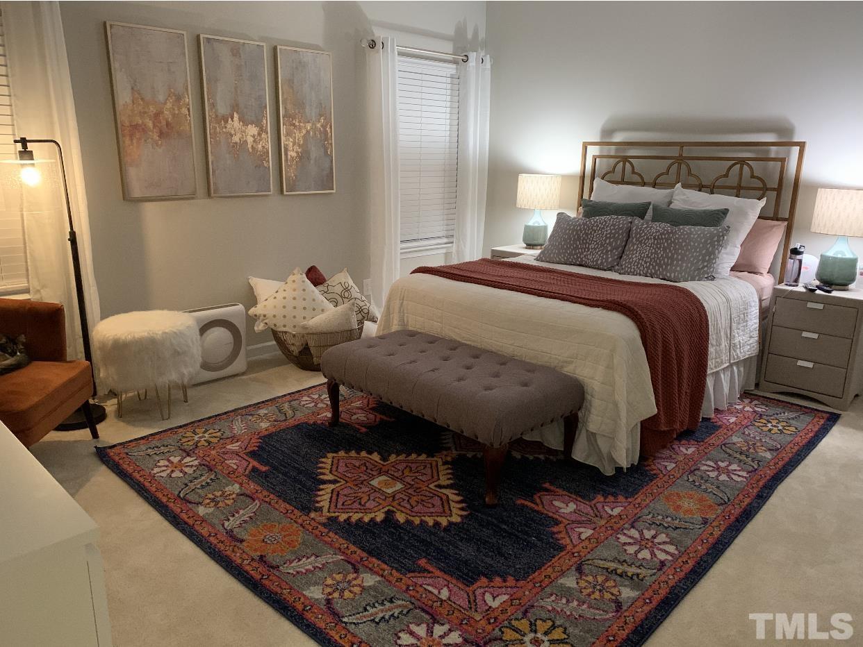 6343 Grace Lily Drive Raleigh, NC 27607 - Photo 2 of 24 a bed sitting in a bedroom next to a window