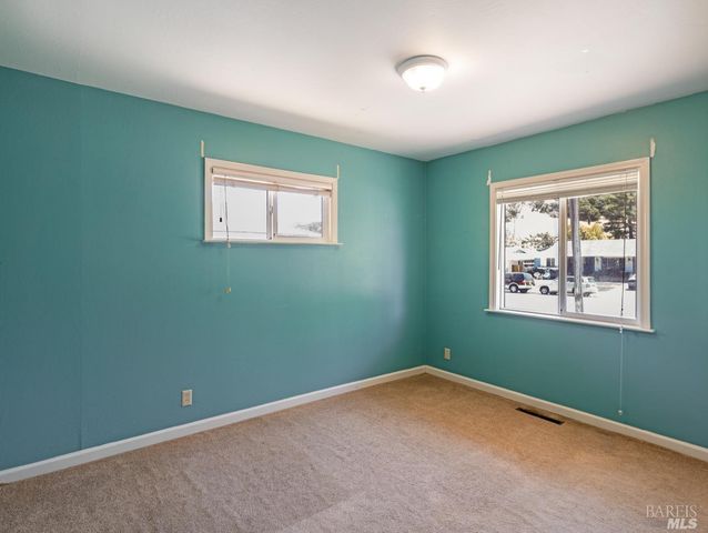 an empty room with closet and a window