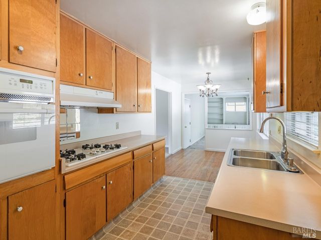 a view of a hallway with wooden floor a chandelier