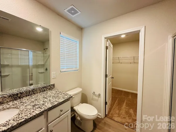 a bathroom with a granite countertop sink toilet and shower