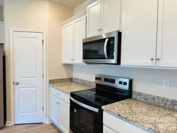a kitchen with microwave cabinets and stove top oven