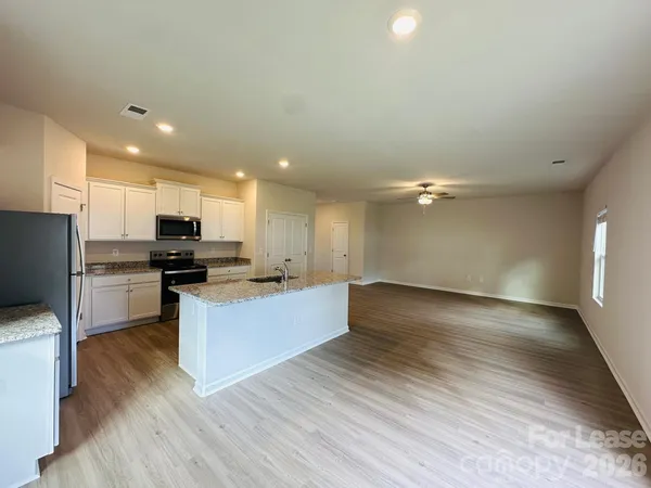 a view of kitchen with wooden floor and electronic appliances