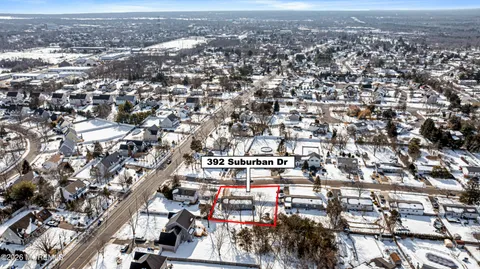 a kitchen with stainless steel appliances granite countertop a refrigerator a stove a sink a dining table and chairs with wooden floor