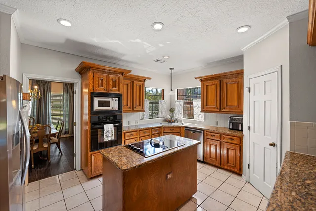 a kitchen with granite countertop a sink and a refrigerator
