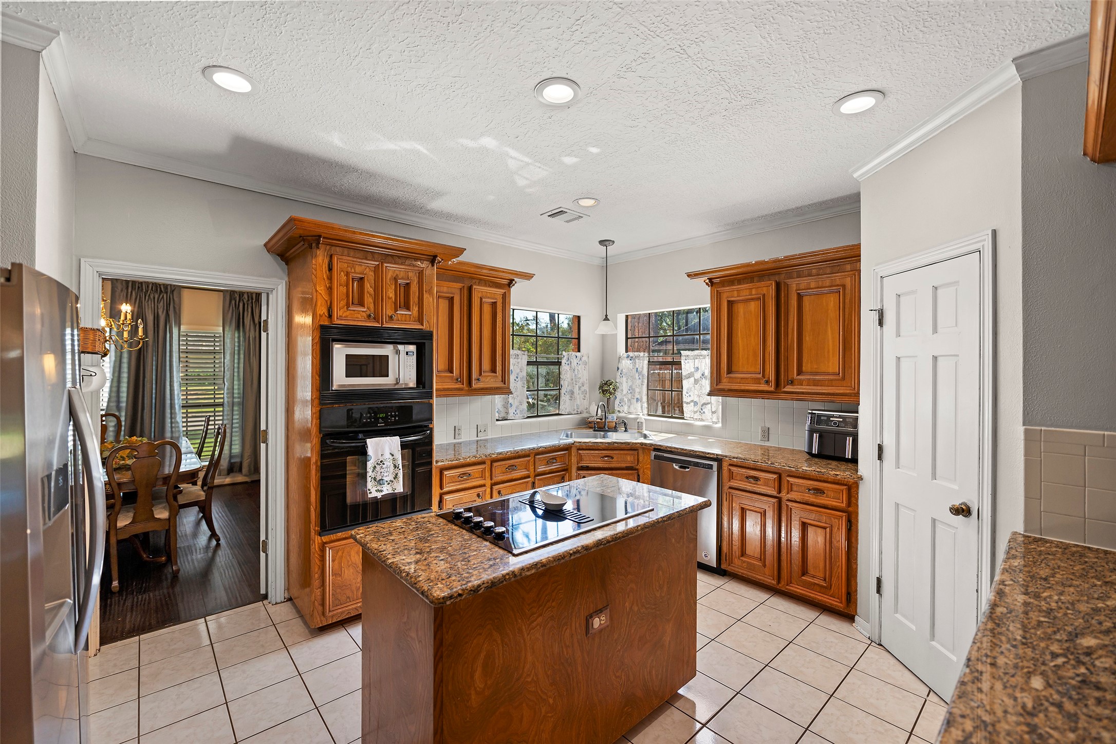 17607 Terrawren Lane Spring, TX 77379 - Photo 11 of 32 a kitchen with granite countertop a sink and a refrigerator