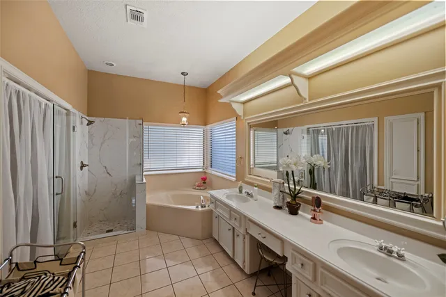 a bathroom with a double vanity sink a mirror and a bathtub