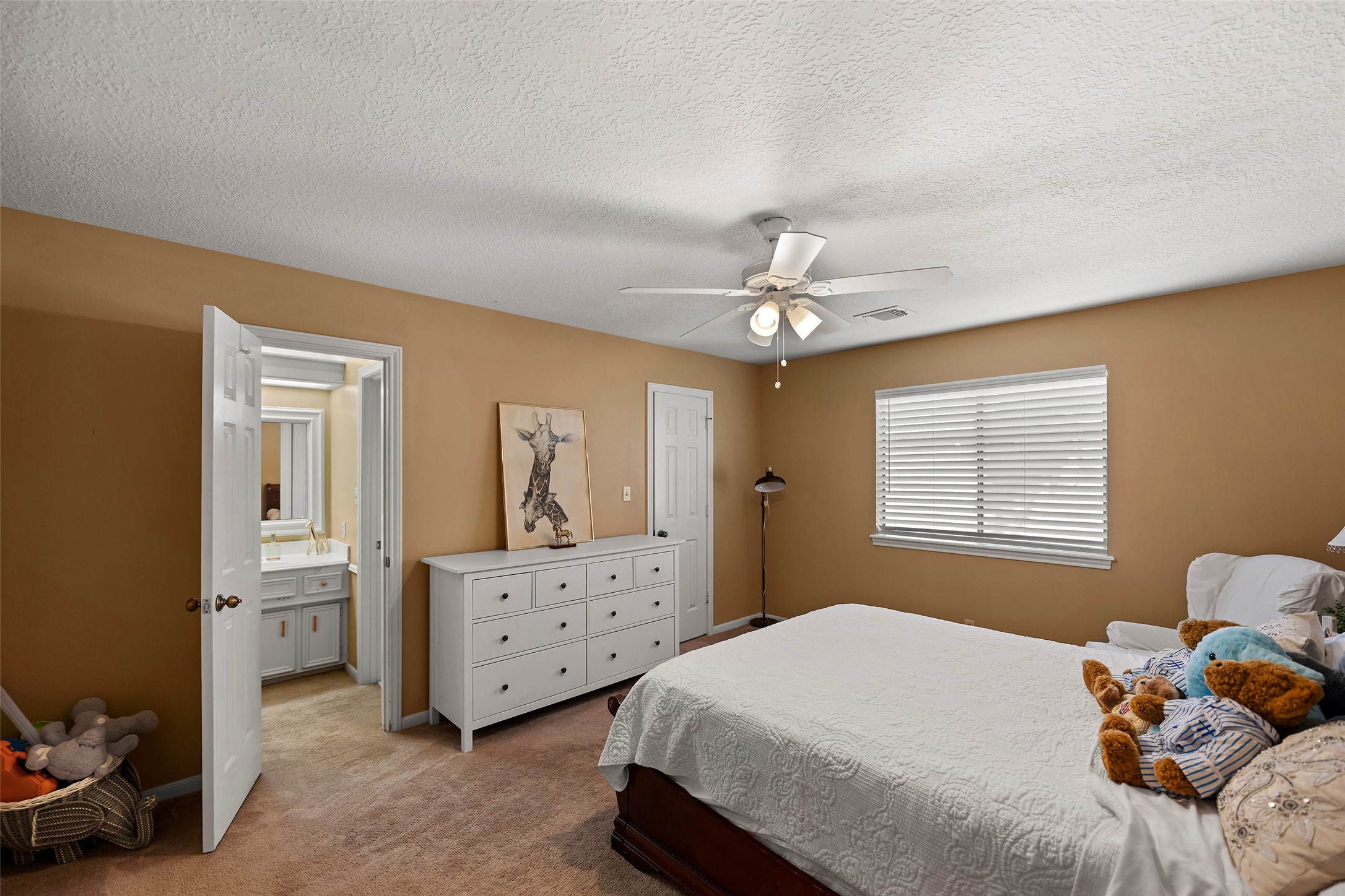 17607 Terrawren Lane Spring, TX 77379 - Photo 19 of 32 a bedroom with a bed and a chandelier