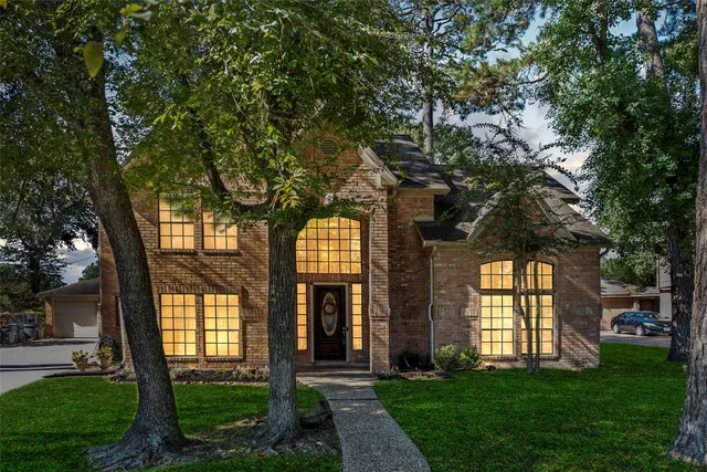 a front view of a house with a garden and trees