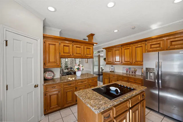a kitchen with stainless steel appliances granite countertop a refrigerator a sink and a stove