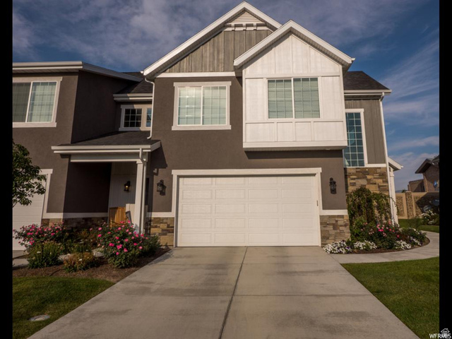9294 South Rose Cottage Way, Unit 207 Sandy, UT 84094 - Photo 1 of 10 Craftsman-style house featuring stone siding, an attached garage, and driveway