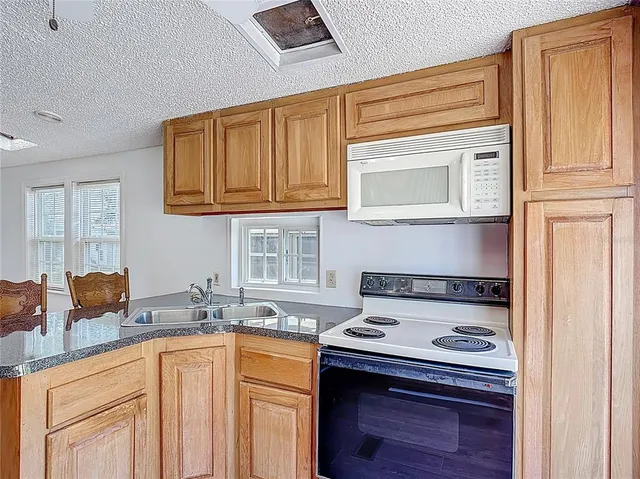 a kitchen with stainless steel appliances granite countertop a stove a sink and a microwave