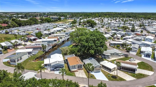 an aerial view of residential houses with outdoor space and trees