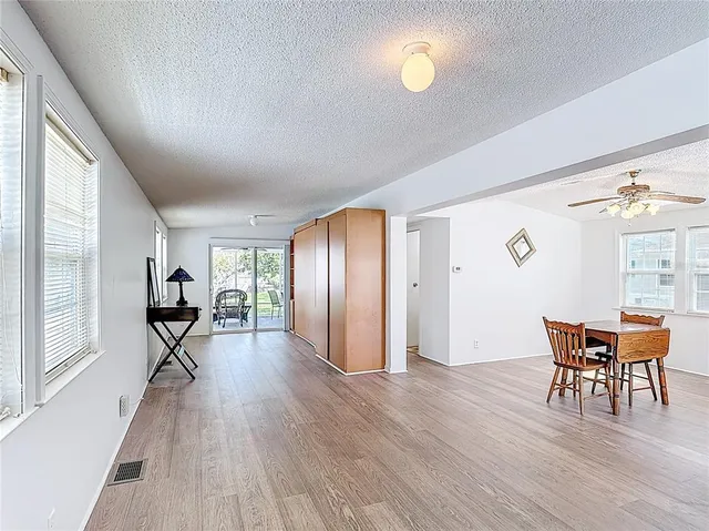 a living room with furniture a dining table and a large window