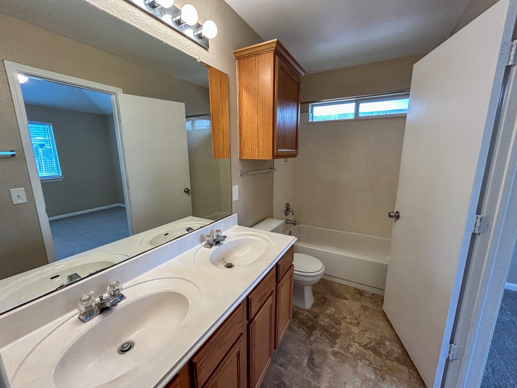1604 Harness Race Way Pflugerville, TX 78660 - Photo 15 of 25 a bathroom with a sink a toilet and shower