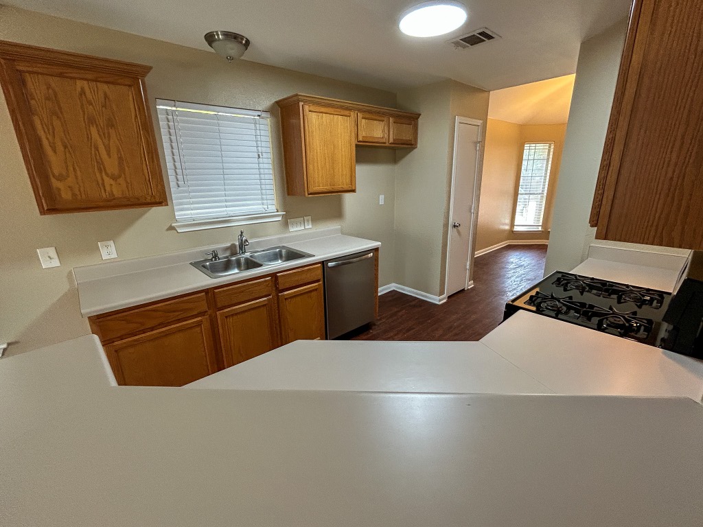 1604 Harness Race Way Pflugerville, TX 78660 - Photo 5 of 25 a kitchen with stainless steel appliances a sink stove and cabinets
