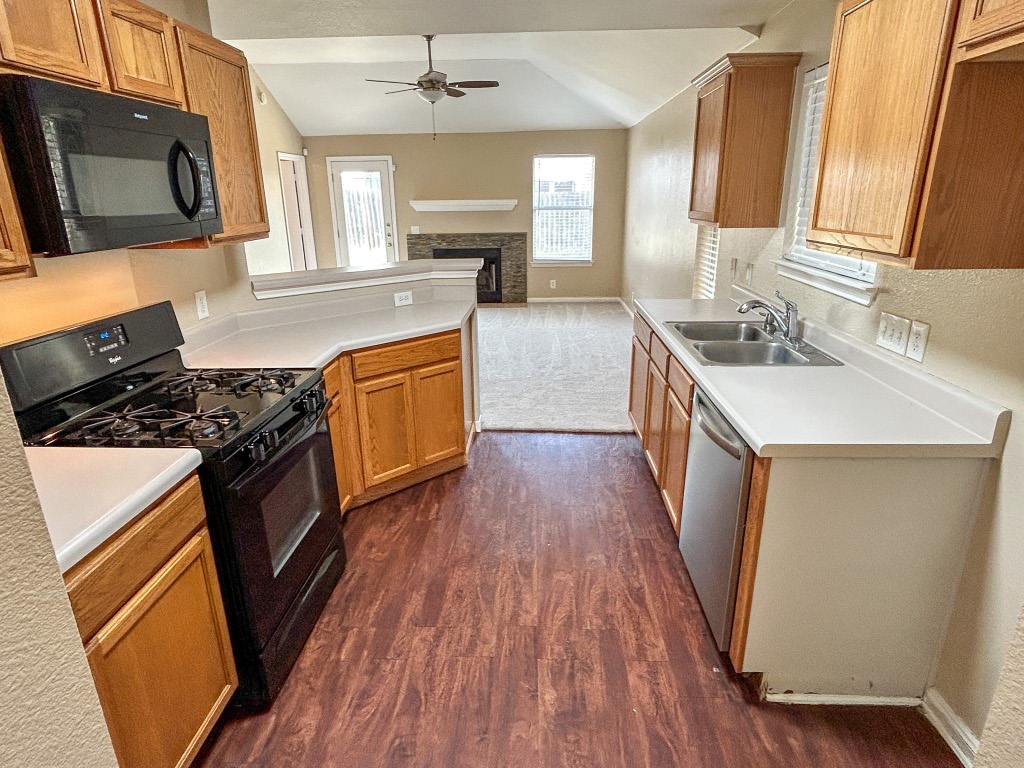 1604 Harness Race Way Pflugerville, TX 78660 - Photo 7 of 25 a kitchen with a sink wooden floor and a stove top oven