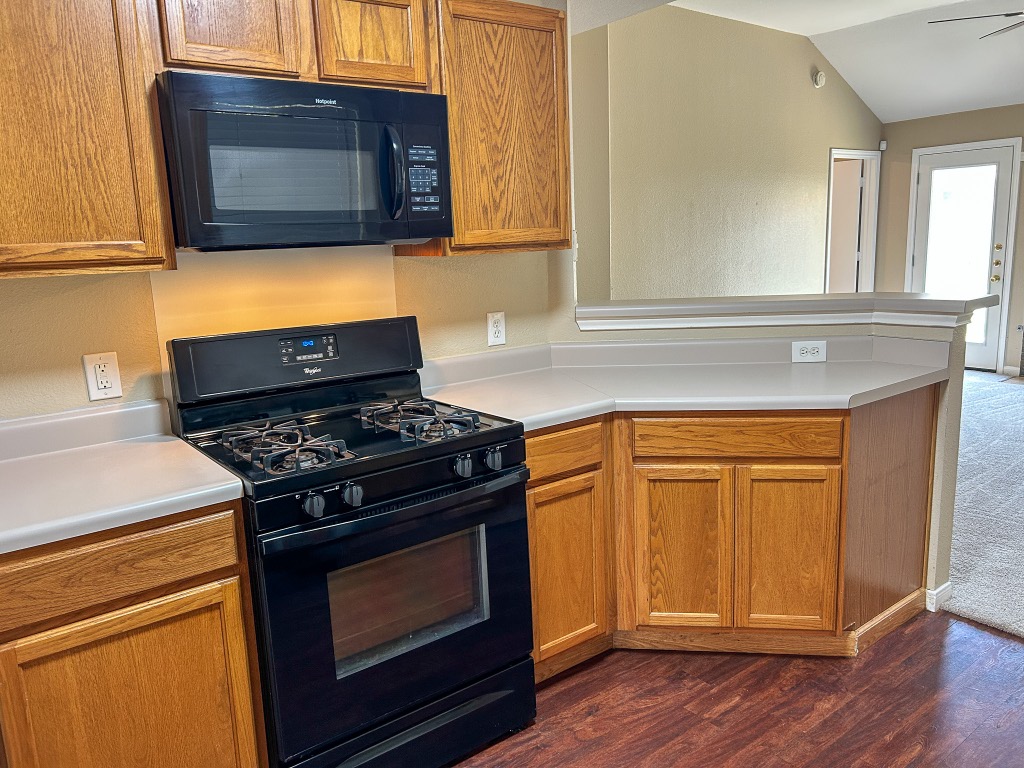 1604 Harness Race Way Pflugerville, TX 78660 - Photo 8 of 25 a kitchen with granite countertop cabinets stainless steel appliances and wooden floor